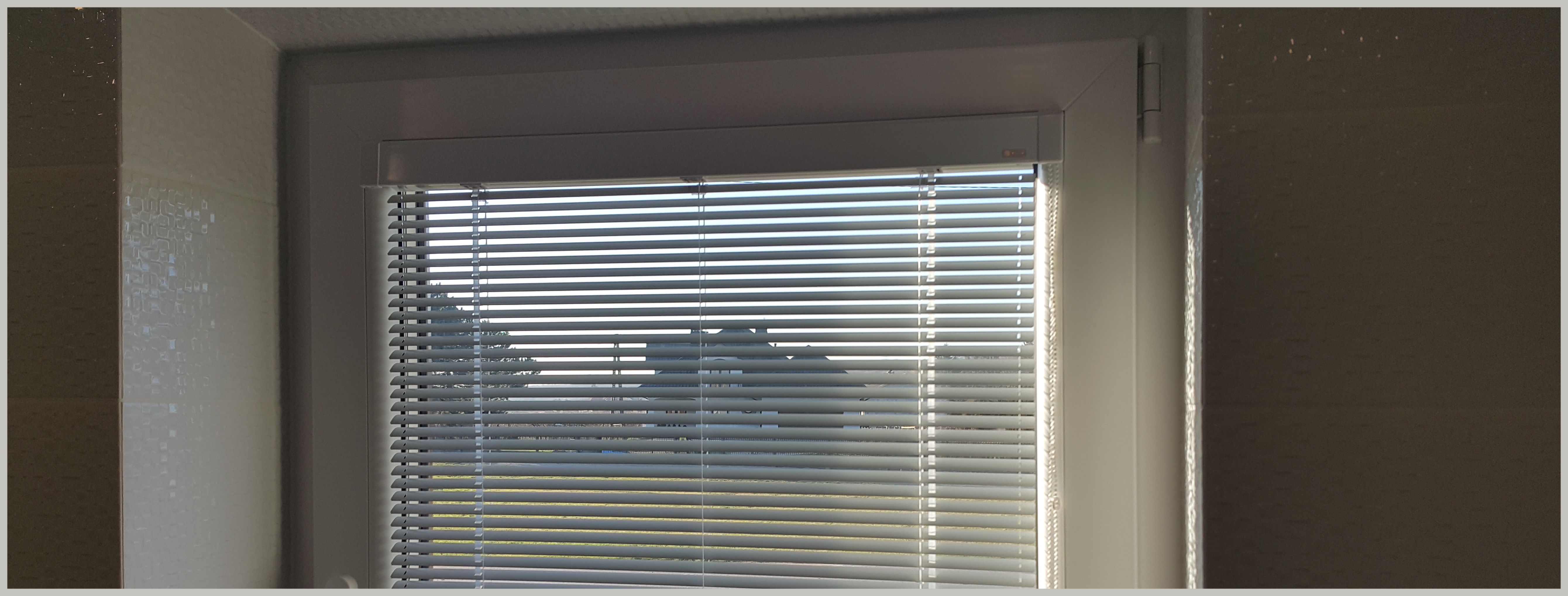 Żaluzja aluminiowa biała 25mm w łazience.